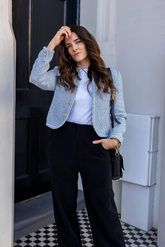 a lady in a white top, a blue tweed jacket and a pair of black pants